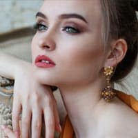 Glamorous woman with flawless skin and elegant jewelry showcasing skincare and beauty treatments at Shrinika Derma Care.