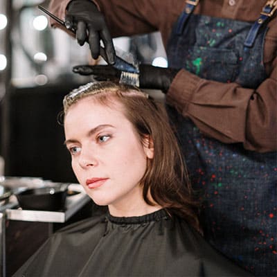 Healthy Caucasian woman getting her hair dyed at a professional salon.