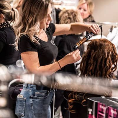 Professional hairstylist styling hair in a salon for healthy, beautiful hair; expert hair care with advanced treatments at Shrinika Derma Care.